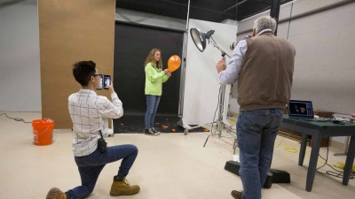 3 people capturing a balloon pop with video equipment