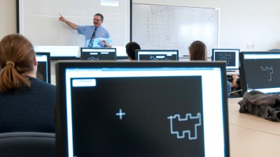 Interior view of the Design and Drafting Lab, showing students working at computers.