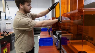 A Fab Lab employee works on a 3D printer.