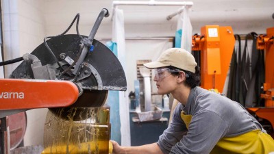 Student cutting a block of glass with a large wet saw