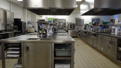 Professional kitchen setup with stainless steel appliances and cooktops