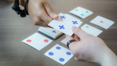 a photo of two people working on a perception activity using cards with symbols