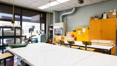 Metal working station with cabinets in against a wall