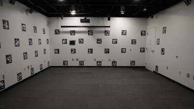 an empty room with gray carpet and white walls with Q R codes on the walls.