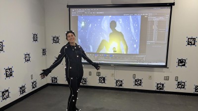 student wearing a suit with sensors in a room that captures movements.