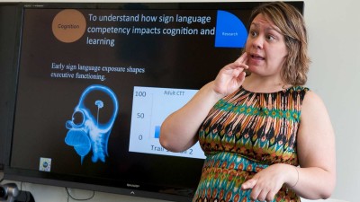 Woman signing in front of a presentation 