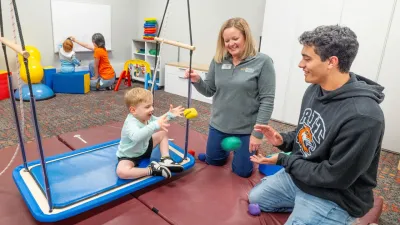 A child and adult toss colorful bean bags to each other.