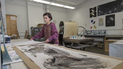 A graduate student works on a project in the Printmaking Studio.