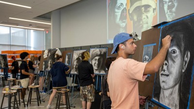 Students draw self-portraits in a classroom.