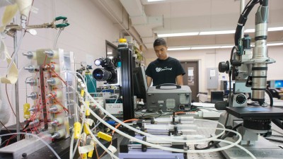 Student working in a lab with lots of testing equipment 