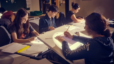 A group of students work at animation light tables.