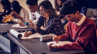 students closely examine everyday objects like a waterbottle and pencil sharpener as they draw them.