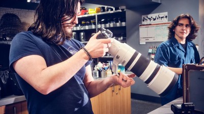 A Cage employee looks at a camera and long lens.