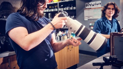 A Cage employee looks at a camera and long lens.