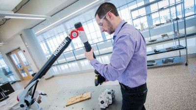 Man with goggles doing a laser scan of a manufacturing part.