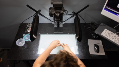 an overhead view of a student placing a form down on the glass surface.