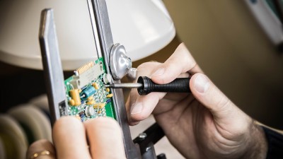 Electronic circuit board being repaired with tool.