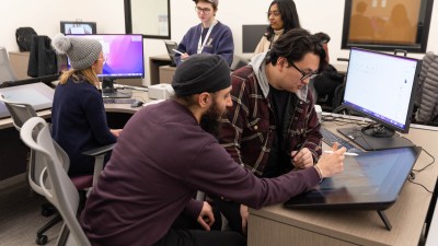 two graduate students collaborate on a drawing on a Cintiq.