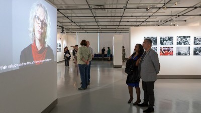 People view a video playing in William Harris Gallery. 
