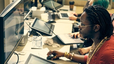 An RIT illustration students looks and works at a computer.