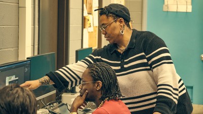 RIT faculty Alesha Williams points at a computer screen for a student she is teaching.