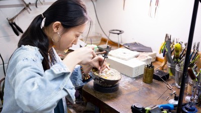 A student works on a jewelry project in their studio space.