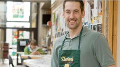 Man wearing a green shirt and a Nathan's bakery apron