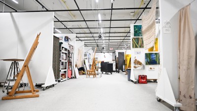 a large studio space broken down into smaller workspaces with walls on wheels.
