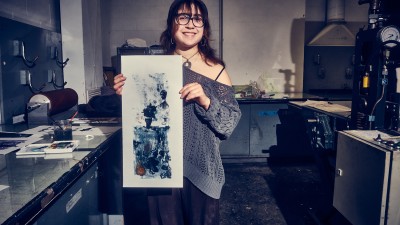 A student holds up their print.