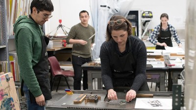 an instructor lines up letters for a print making demonstration.
