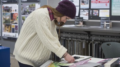 A student looks at material and color options for a project from the RIT interior design program's Material Resource Center.