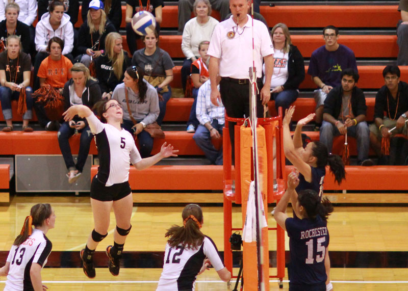 people playing volleyball, one player is about to try to spike the ball