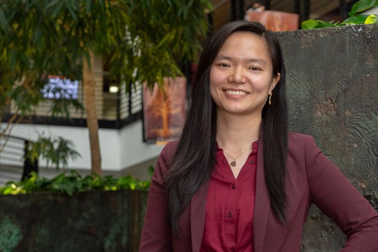 researcher posing in lobby of building.