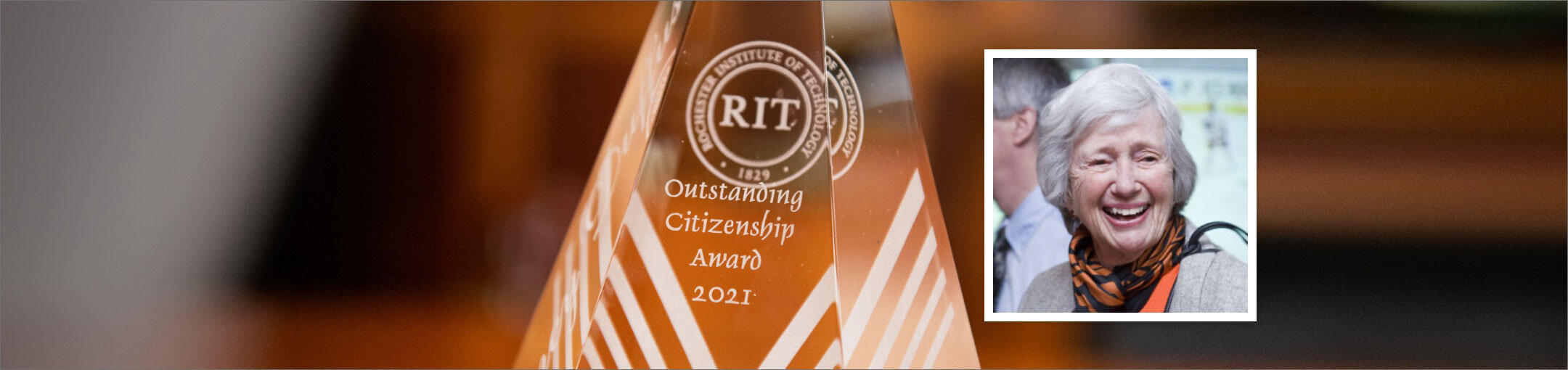 The Dancy Duffus award for Outstanding Citizenship sitting on a table next to an image of Dancy Duffus.