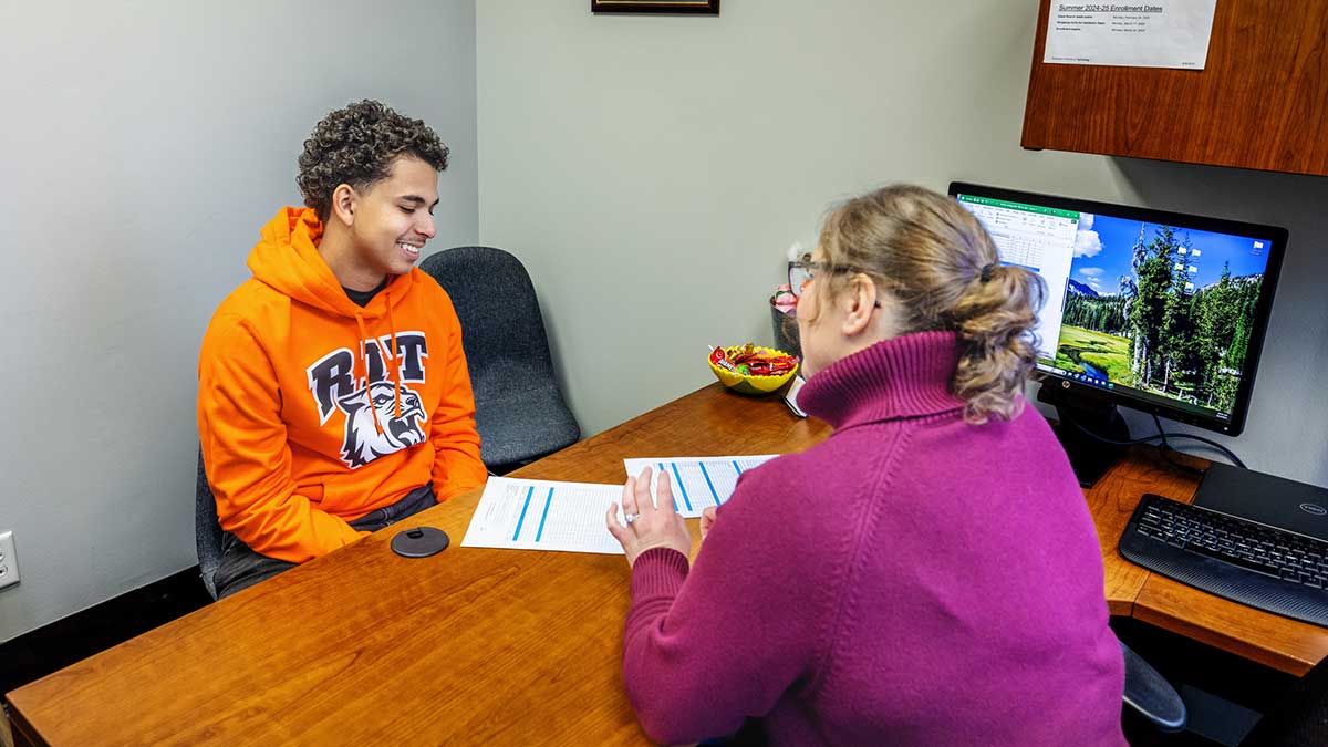 advisor and student talking in an office setting.
