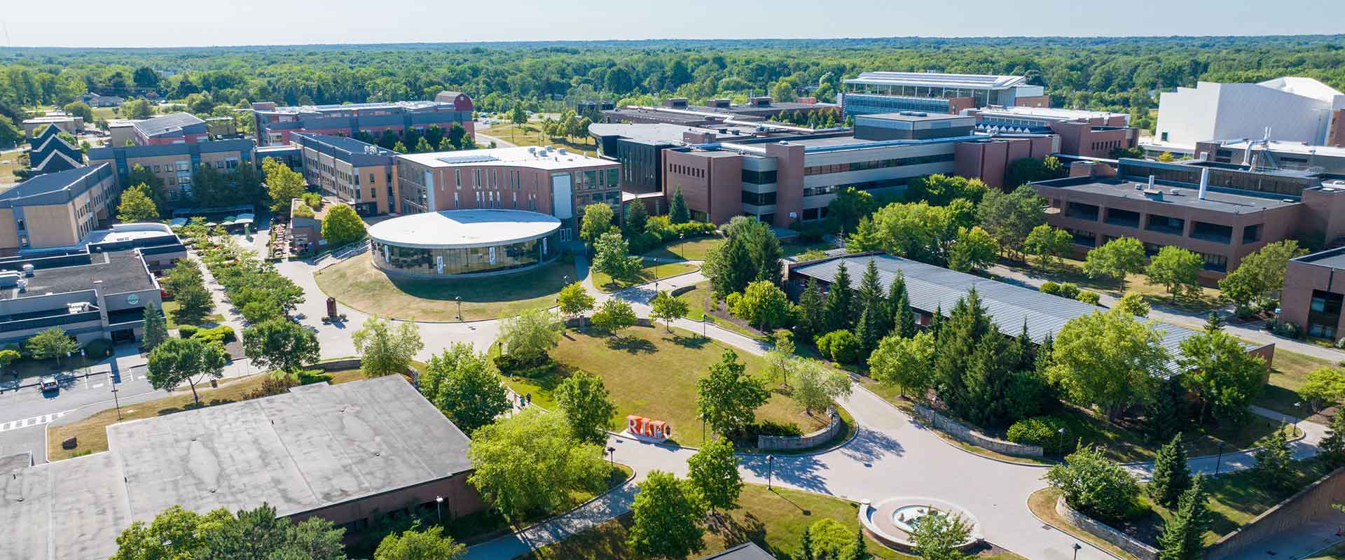 aerial view of brick and glass buildings and green spaces on the R I T campus.