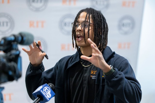  A student speaks into a reporter's microphone