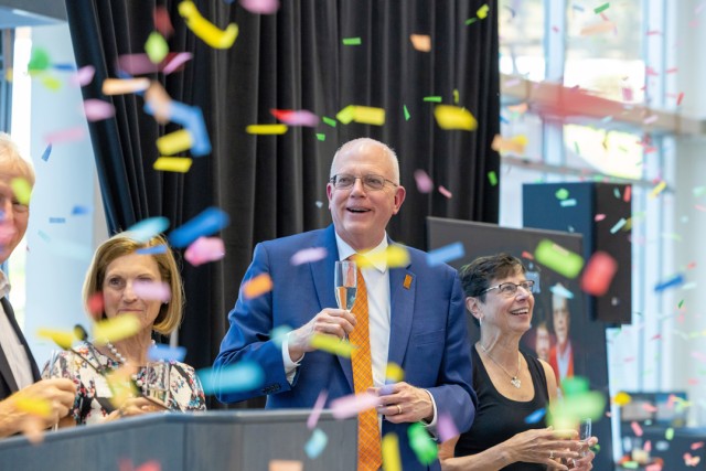 Confetti flies in the air in front of smiling people