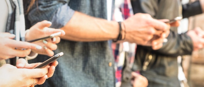 A group of people's arms holding cell phones