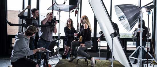 Behind the scenes view of a photoshoot with lights and models