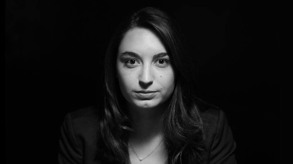 A group of students sitting outside at global village working on their laptops