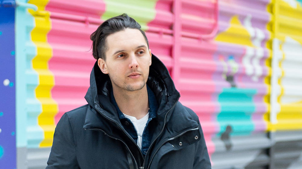 Allison Ritter pointing a remote offscreen in a dark room with computers in it