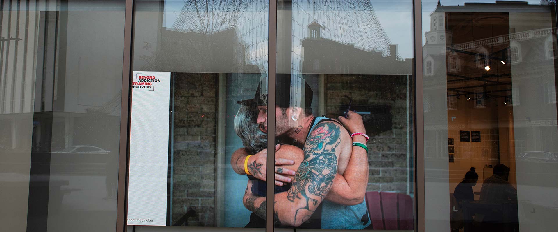 two people embrace behind a glass door.