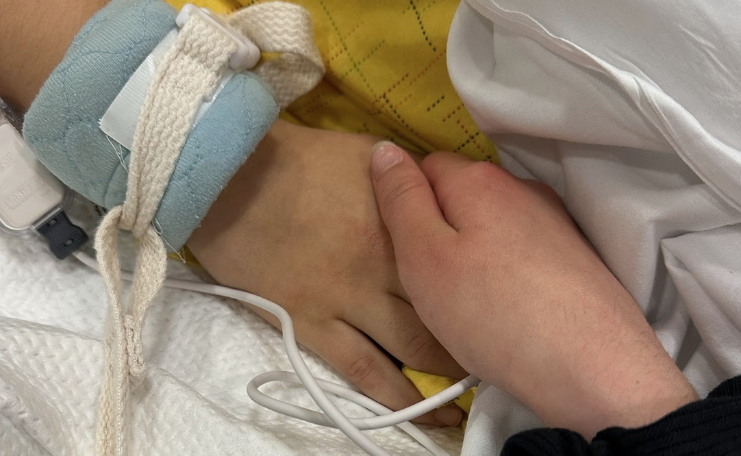 hands holding in hospital bed