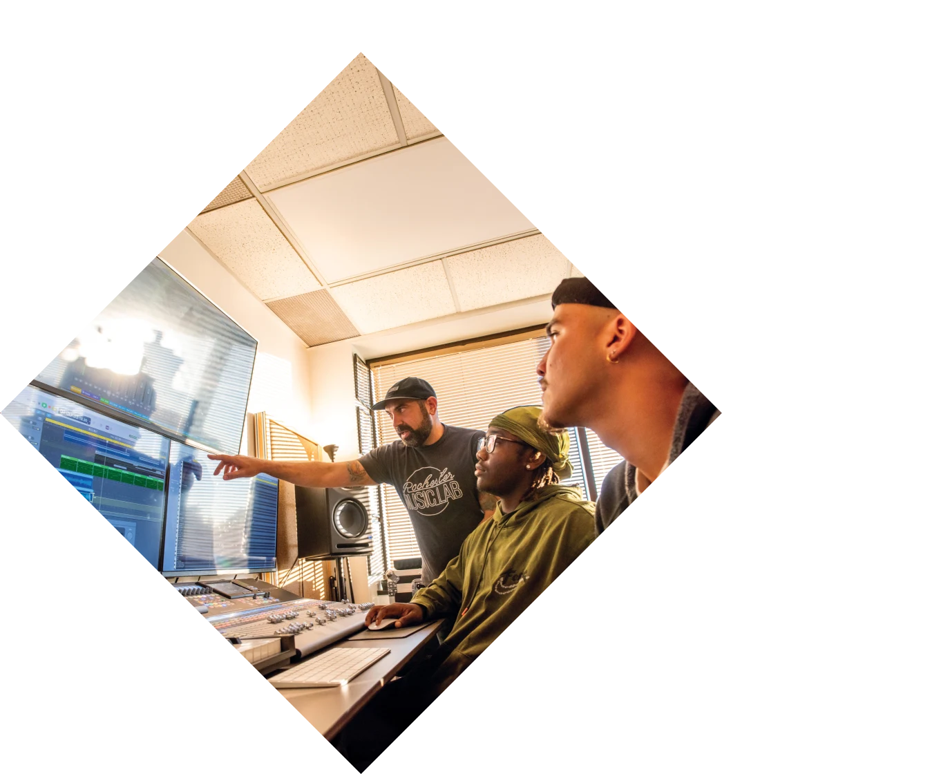 Orange hue with two people sitting at a computer with glasses and microphones