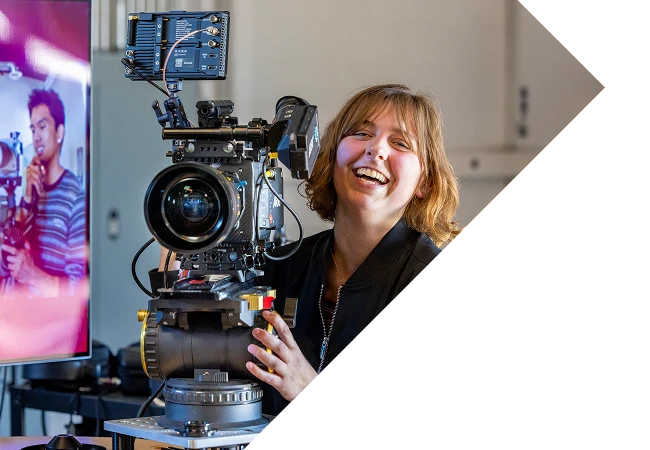 woman smiling while holding a film camera