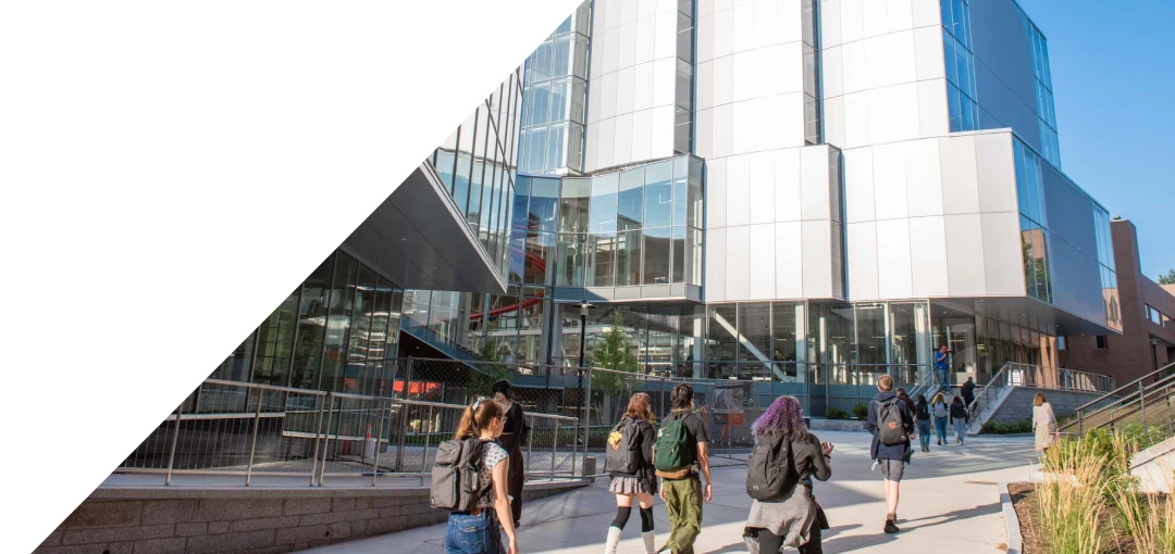 Students walking on campus in front of the SHED