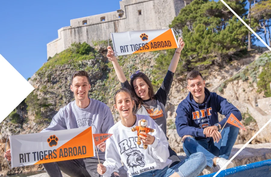 Students in Croatia posing in front of a castle wall outside