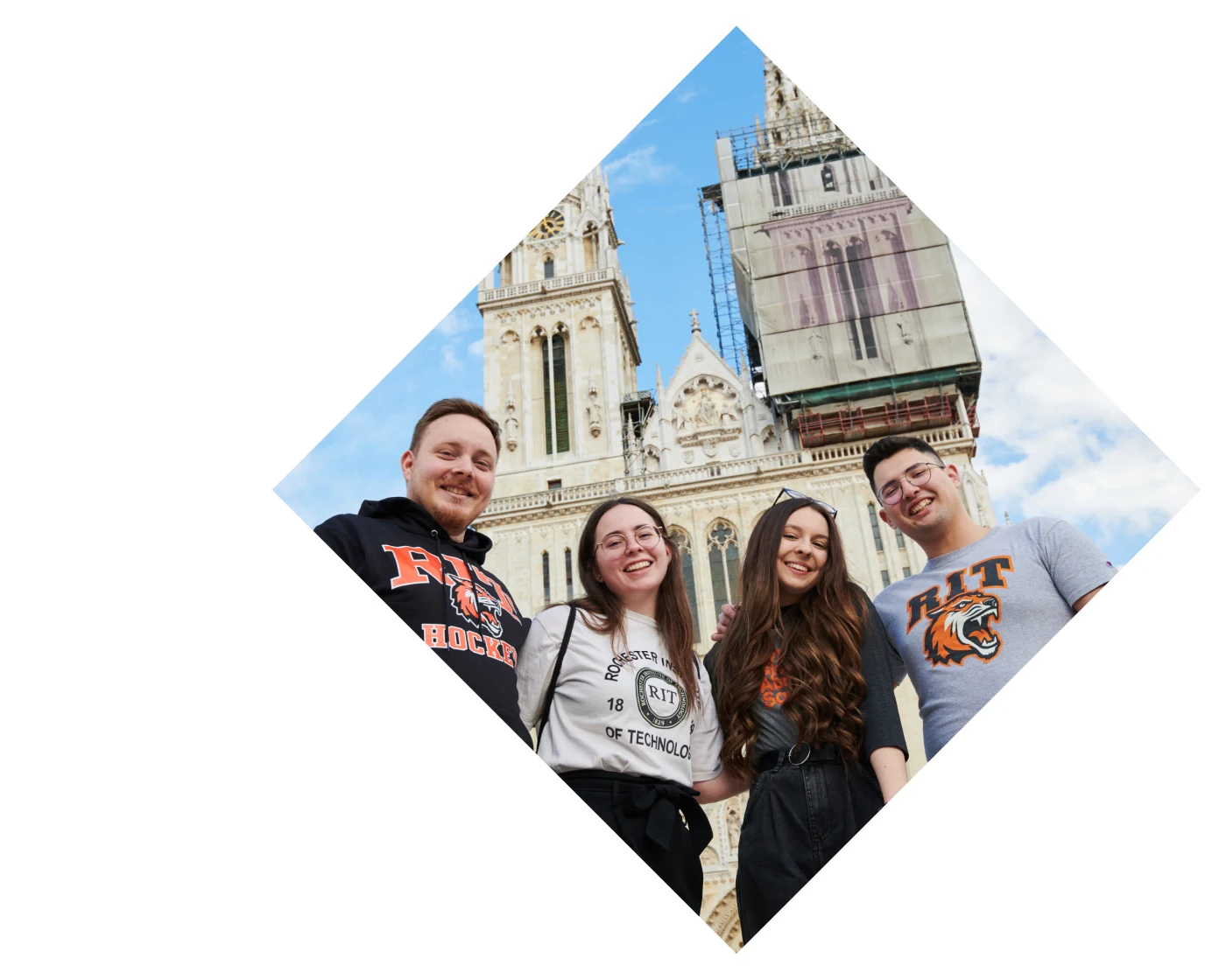 Students in RIT gear standing in front of an old building
