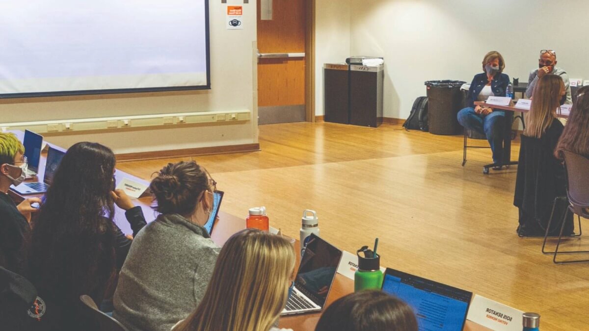 A group of people during a senate meeting 